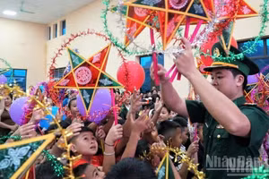 Les enfants reçoivent avec joie des lanternes traditionnelles en forme d’étoile à cinq branches. Photo : NDEL