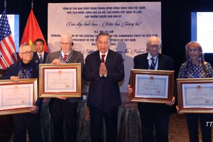 Le secrétaire général du PCV et président To Lam (centre) remet à titre posthume l'Ordre de l'Amitié à des amis américains. Photo : VNA.