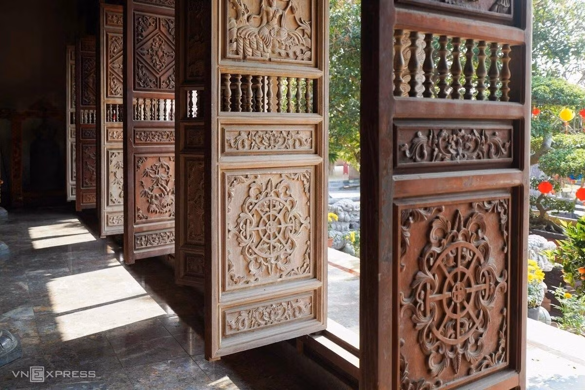 Les portes en bois de la pagode sont finement sculptées de motifs emblématiques de l'art bouddhique vietnamien, représentant notamment des lotus, des nuages et des dragons. Photo : Hoang Giang