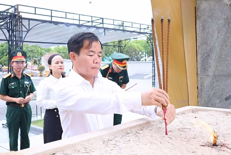 Nguyen Van Phuong brûle de l’encens devant le monument principal du Cimetière national des morts pour la Patrie de la Route 9.