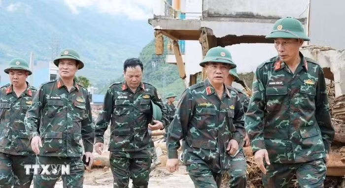 Le général de division Nguyen Dang Khai (2e à partir de la droite), chef d’état-major adjoint et commandant adjoint de la 2e Région militaire, inspecte les opérations de secours et de reconstruction à Muong Than. Photo : NDEL.