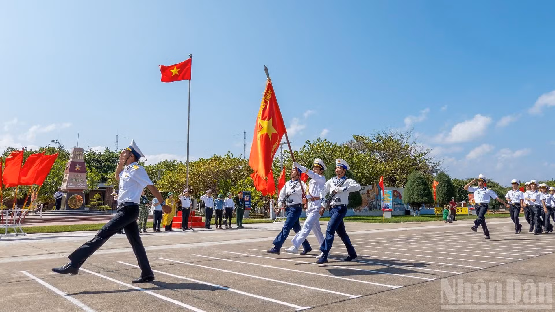 La revue des troupes se déroule sous le drapeau national et à proximité de la borne marquant la souveraineté sur l’archipel de Truong Sa. Photo : NDEL