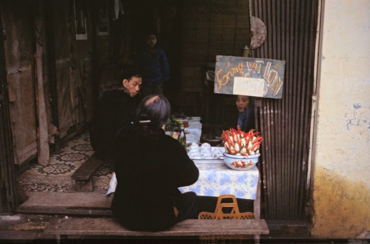 Le photographe néerlandais Ab Stokvis a immortalisé une échoppe vendant des œufs de canard fécondés dans les années 1980. Le long banc en bois et la nappe à motifs floraux étaient alors des éléments familiers du quotidien et des activités commerciales de l’époque. Photo : vnexpress.net