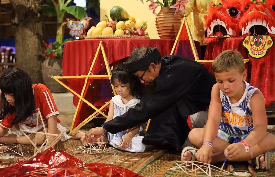 La fabrication ensemble des lanternes pour célébrer la fête de la pleine lune est une activité qui séduit aussi bien les enfants que les adultes. Photo : baovanhoa.vn