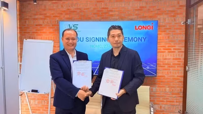 Les représentants de Viet Sin Energy Group et de LONGi échangent les documents de l'accord de coopération.
