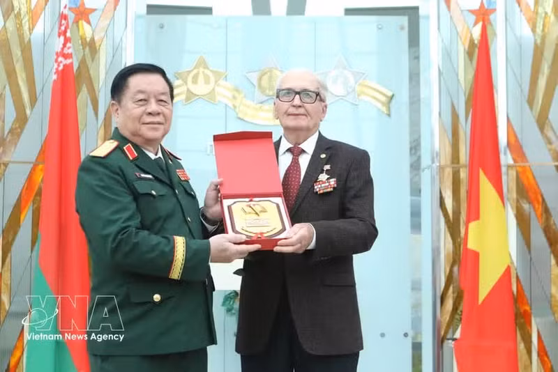 Le général Nguyen Trong Nghia, chef du Département général de la politique (gauche), offre un cadeau à Vasily Ivanovich Braga, président de l'Association des anciens experts militaires biélorusses ayant aidé le Vietnam. Photo: VNA.