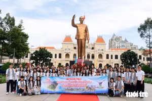 Les jeunes Vietnamiens de l’étranger déposent des fleurs devant la statue du Président Hô Chi Minh, sur la rue piétonne Nguyen Hue, le matin du 25 août. Photo : Tuoitre.