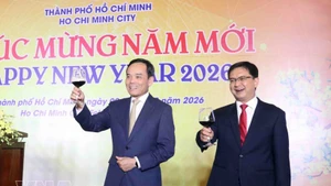 Tran Luu Quang (à gauche), membre du Bureau politique et secrétaire du Comité du Parti de Hô Chi Minh-Ville, à la rencontre. Photo : VNA