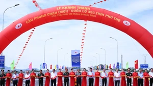 Le Premier ministre Pham Minh Chinh et les délégués ont coupé le ruban pour inaugurer le nouveau pont Phong Chau sur la Route Nationale 32C. Photo: NDEL