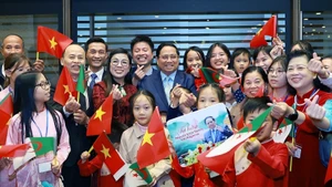 Le Premier ministre Pham Minh Chinh et son épouse avec les cadres, le personnel de l'ambassade du Vietnam et les représentants de la communauté vietnamienne en Algérie. Photo : VNA