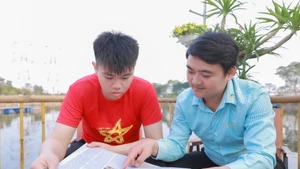 Des jeunes du Groupe 4 (rue Tinh Quang, quartier de Viet Hung, Hanoï) s’informent sur le XIVe Congrès du Parti via la presse, exprimant leur confiance dans la réussite du Congrès. Photo : VNA