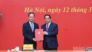 Le Premier ministre Pham Minh Chinh remet la décision à Tran Hong Thai pour sa nomination à la présidence de l'Académie. Photo : NDEL