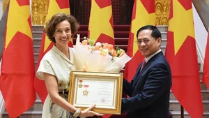 Le vice-Premier ministre et ministre des Affaires étrangères Bui Thanh Son remet à la directrice générale de l’UNESCO, Audrey Azoulay, l’insigne « Pour la cause de la diplomatie vietnamienne». Photo : VNA.