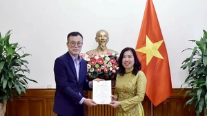 La vice-ministre des Affaires étrangères Lê Thi Thu Hang remet la licence à Kim Kwan Woong, chef du bureau et correspondant résident de Financial News au Vietnam. Photo: ministère des Affaires étrangères