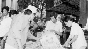 Des habitants de la capitale achètent le « Journal de l'après-midi » de VNA pour suivre les nouvelles de la clôture du 7e Congrès national du Parti (17 juillet 1991). Photo : VNA.