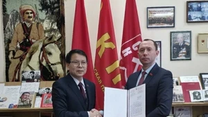Sergueï Syrankov, premier secrétaire du Comité central du Parti communiste de Biélorussie, remet une lettre de félicitations à l'ambassadeur du Vietnam en Biélorussie, Nguyen Van Trung (gauche). Photo : VNA.