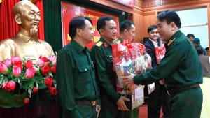 Le général de brigade Tran Minh Trong, commissaire politique adjoint de la Région militaire 5, remet des cadeaux aux dirigeants des administrations locales et aux forces armées locales. Photo : VOV.