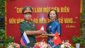 Le général Luu Trong Lu, président de l’Association des anciens combattants de la province de Dien Bien, remet l’urne contenant la terre sacrée à Vu Thi Tuyet Nga, directrice du Musée de la Victoire de Diên Biên Phu. Photo : VNA.
