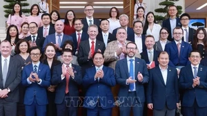 Le Premier ministre Pham Minh Chinh pose pour une photo souvenir avec les délégués lors de l'événement, à Hanoi, le 28 juin. Photo : VNA.