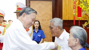 Le secrétaire général To Lam offre des cadeaux aux familles des personnes méritantes. Photo : VNA