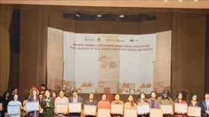 La directrice du Département de la Culture et des Sports de Hanoï, Mme Bach Lien Huong (3e, gauche), remet le certificat d'espace culturel créatif de Hanoï aux représentants des espaces culturels créatifs. Photo : VNA.