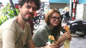 Des touristes dégustent du « bánh mì ». Photo: VNA