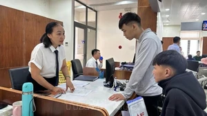 Le personnel du Centre de services administratifs publics du quartier de Tam Ky, dans la ville de Dà Nang, guide les gens dans les procédures administratives. Photo : VNA.