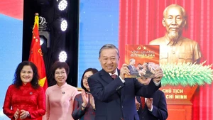 Le secrétaire général du Parti, To Lam, reçoit l’album photo « La gloire appartient à jamais au Peuple », offertpar l’Agence vietnamienne d’Information. Photo : VNA.