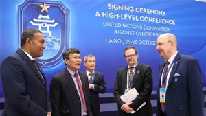 Le vice-ministre permanent vietnamien des Affaires étrangères Nguyen Minh Vu avec les délégués participant à la cérémonie de signature de la Convention de Hanoi le matin du 25 octobre. Photo : VNA