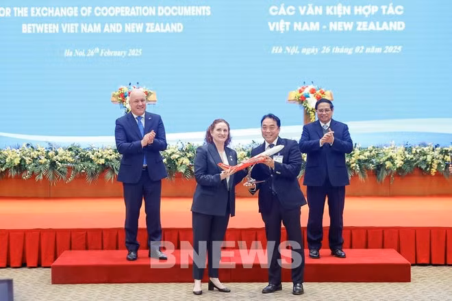 L'ambassadrice de Nouvelle-Zélande au Vietnam, Caroline Beresford, remet le certificat d'ouverture de la nouvelle ligne aérienne direct reliant Ho Chi Minh-Ville à Auckland au vice-président du conseil d'administration de Vietjet, Nguyen Anh Tuan, en présence des Premiers ministres du Vietnam et de la Nouvelle-Zélande. Photo : VNA.