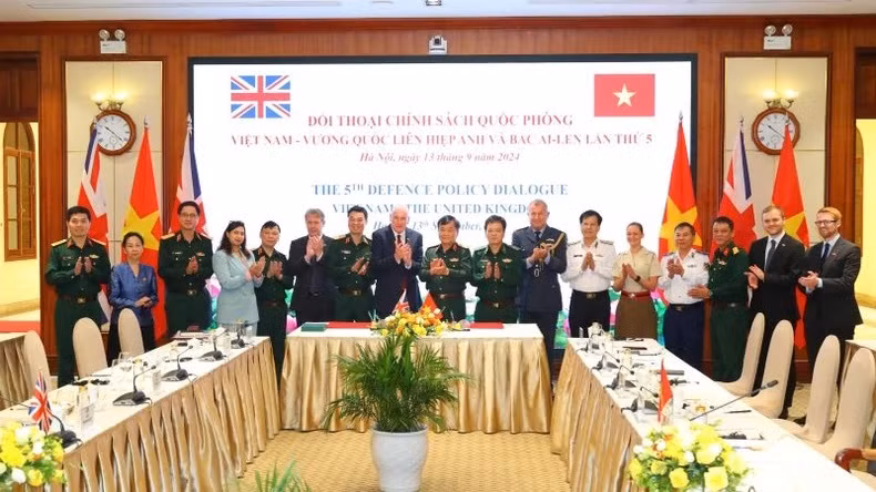 Le général de corps d’armée Hoang Xuan Chien, M. Vernon Coaker et les délégués ont pris une photo ensemble.