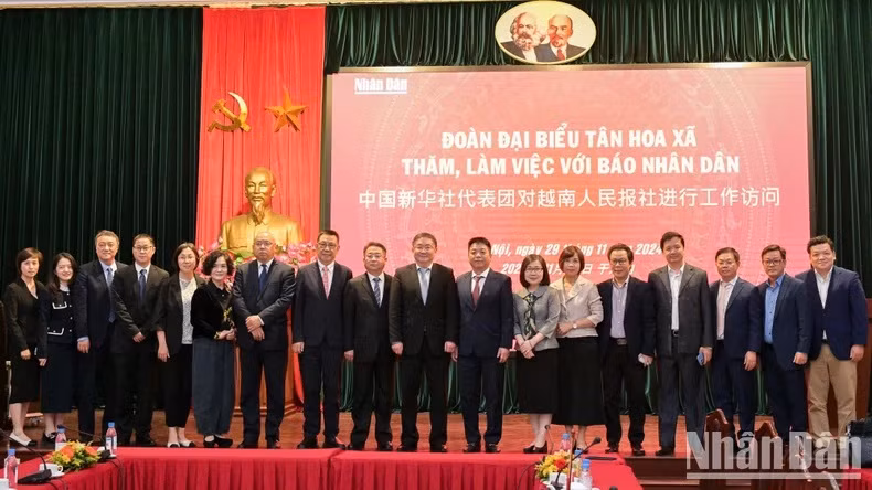 Le rédacteur en chef adjoint du journal Nhân Dân, Quê Dinh Nguyên, la vice-directrice générale de l’Agence vietnamienne de presse, Doan Thi Tuyêt Nhung, et le rédacteur en chef adjoint de Xinhua, Ren Weidong, accompagnés des dirigeants du journal Nhân Dân et des membres de la délégation de Xinhua, posent pour une photo de groupe.