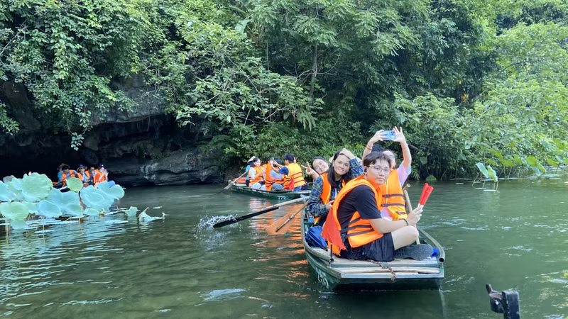 Les jeunes Viêt kiêu sont ravis d’avoir pu faire du kayak et contempler les paysages à Tràng An. Photo : thoidai.com.vn