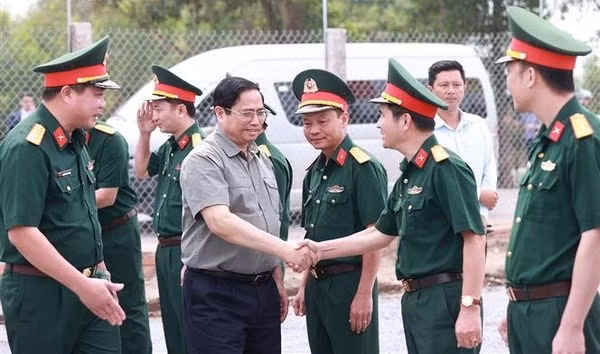 Le Premier ministre et des responsables du Corps d'armée 12 (Compagnie générale de la construction Truong Son). Photo : VNA.