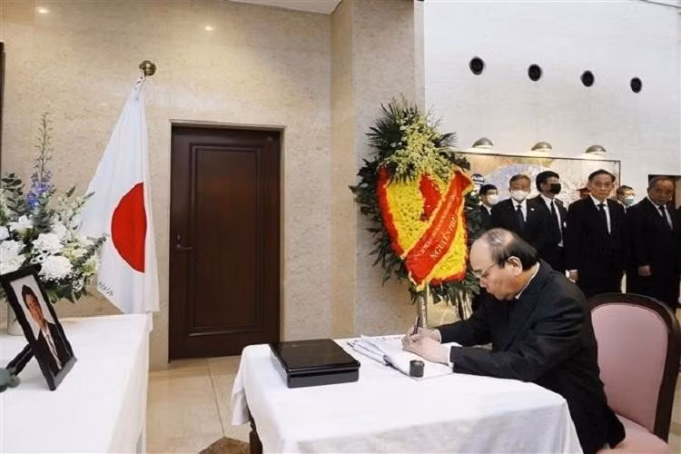 Le Président Nguyên Xuân Phuc écrit dans le registre de condoléances en mémoire de feu le Premier ministre Abe. Photo : baoquocte.