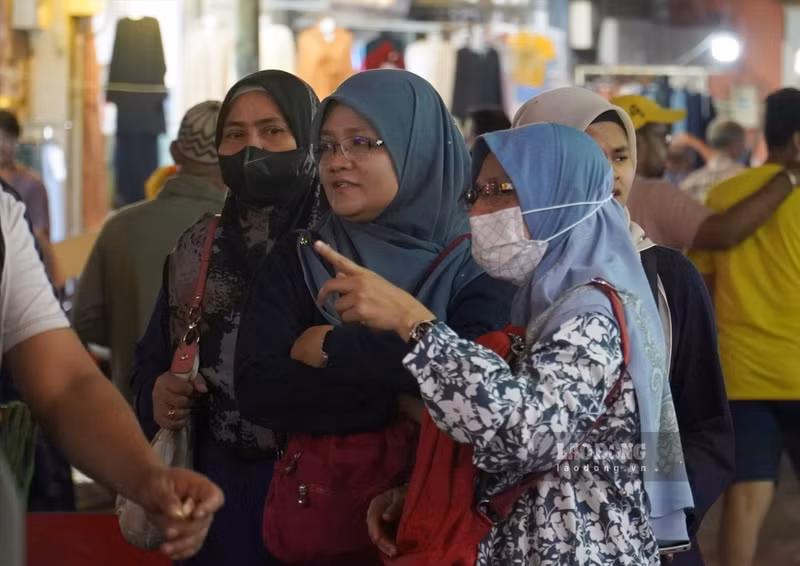 Des touristes portent le hijab traditionnel. Photo : laodong.vn