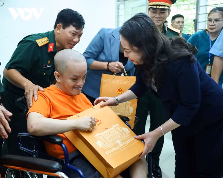 La vice-présidente Vo Thi Anh Xuan offre un cadeau à une victime du Centre de soins et de traitement des victimes de l’agent organe/dioxine de Hanoï. Photo : VOV.