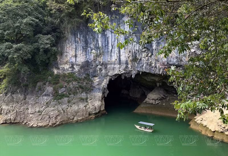 Touristes en bateau pour découvrir la montagne Mat Thân Nui et les alentours du lac Thang Hen. Photo : VNP.