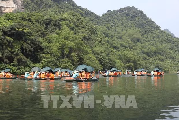 Des touristes au complexe paysager de Trang An, dans la province de Ninh Binh, - premier patrimoine mixte culturel et naturel du Vietnam à être inscrit dans la Liste du patrimoine mondial de l’UNESCO. Photo: VNA.