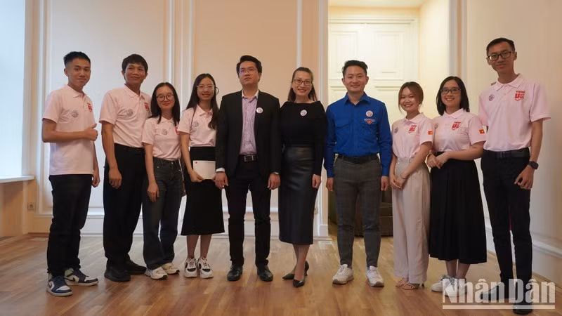 Des étudiants vietnamiens participent à l’enseignement du programme « Tiếng Việt vui » et les délégués prennent des photos souvenirs. Photo ; thoidai.com.vn