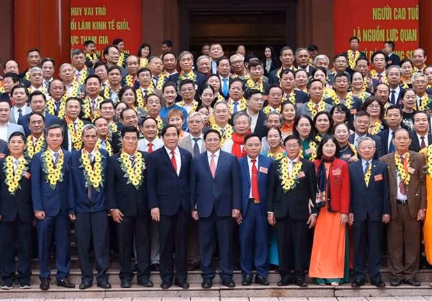 Le Premier ministre Pham Minh Chinh pose avec les entrepreneurs seniors excellents, à Hanoi, le 16 novembre. Photo : VNA.