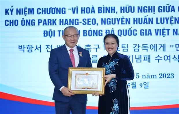 La présidente de l'Union des Organisations d’Amitié du Vietnam, l’ambassadrice Nguyên Phuong Nga, remet l'Insigne "Pour la paix et l'amitié entre les nations" à Park Hang-seo, le 9 mai à Hanoï. Photo : VNA.