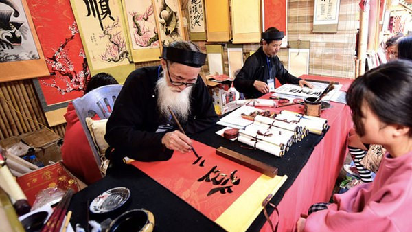 Demander une calligraphie, une belle coutume des Vietnamiens. Photo : VNA.