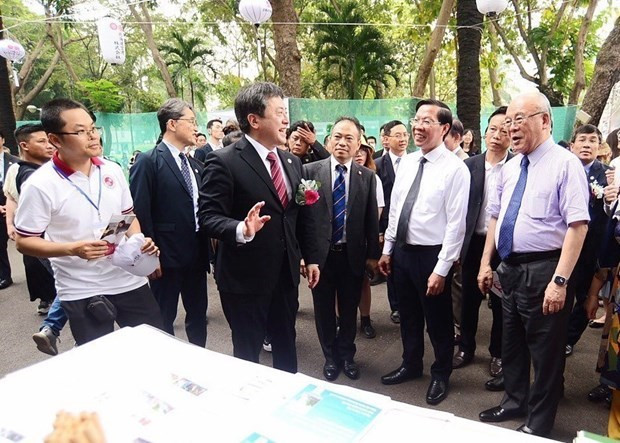 Des responsables vietnamiens et japonais visitent des stands lors du festival. Photo : VNA