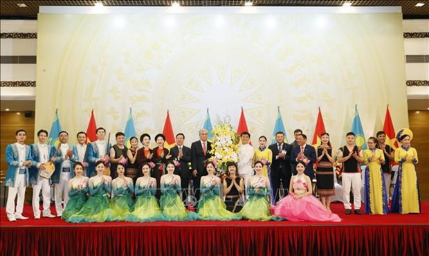 Le Président vietnamien, Vo Van Thuong, et le Président du Kazakhstan, Kassym-Jomart Tokaïev, offrent des fleurs aux artistes lors de la réception. Photo : VNA.