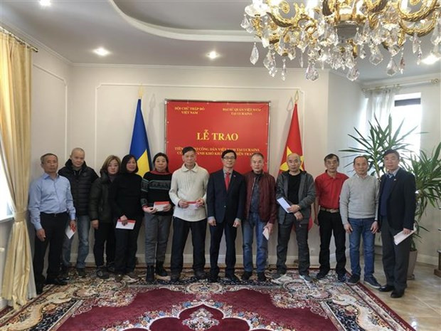 Remise de l'aide financière aux citoyens vietnamiens en situation difficile dans la capitale ukrainienne Kiev. Photo : VNA.