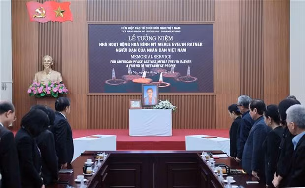 Les délégués observent une minute de silence en mémoire de Mme Merle Ratner. Photo: VNA