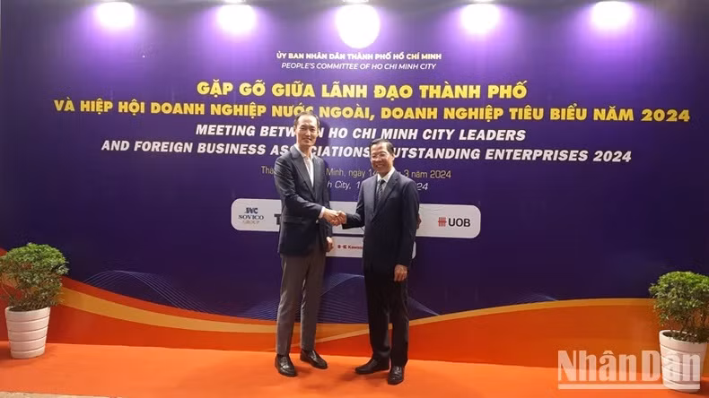 Le président du Comité populaire de Hô Chi Minh-Ville, Phan Van Mai (à droite) et un délégué lors de la rencontre, à Hô Chi Minh-Ville, le 14 mars. Photo : NDEL