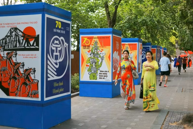Les habitants profitent des décorations festives, notamment dans les environs du lac Hoan Kiem, pour profiter du beau temps. Avec des températures fraîches et un soleil radieux, c'est le moment idéal pour participer aux activités et événements marquant cet anniversaire important. Photo : baoquocte.vn
