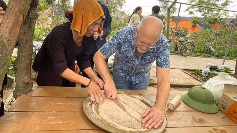 Un touriste participe à la préparation du chè lam (barres de riz gluant vietnamiennes aux cacahuètes et au gingembre). Photo : NDEL